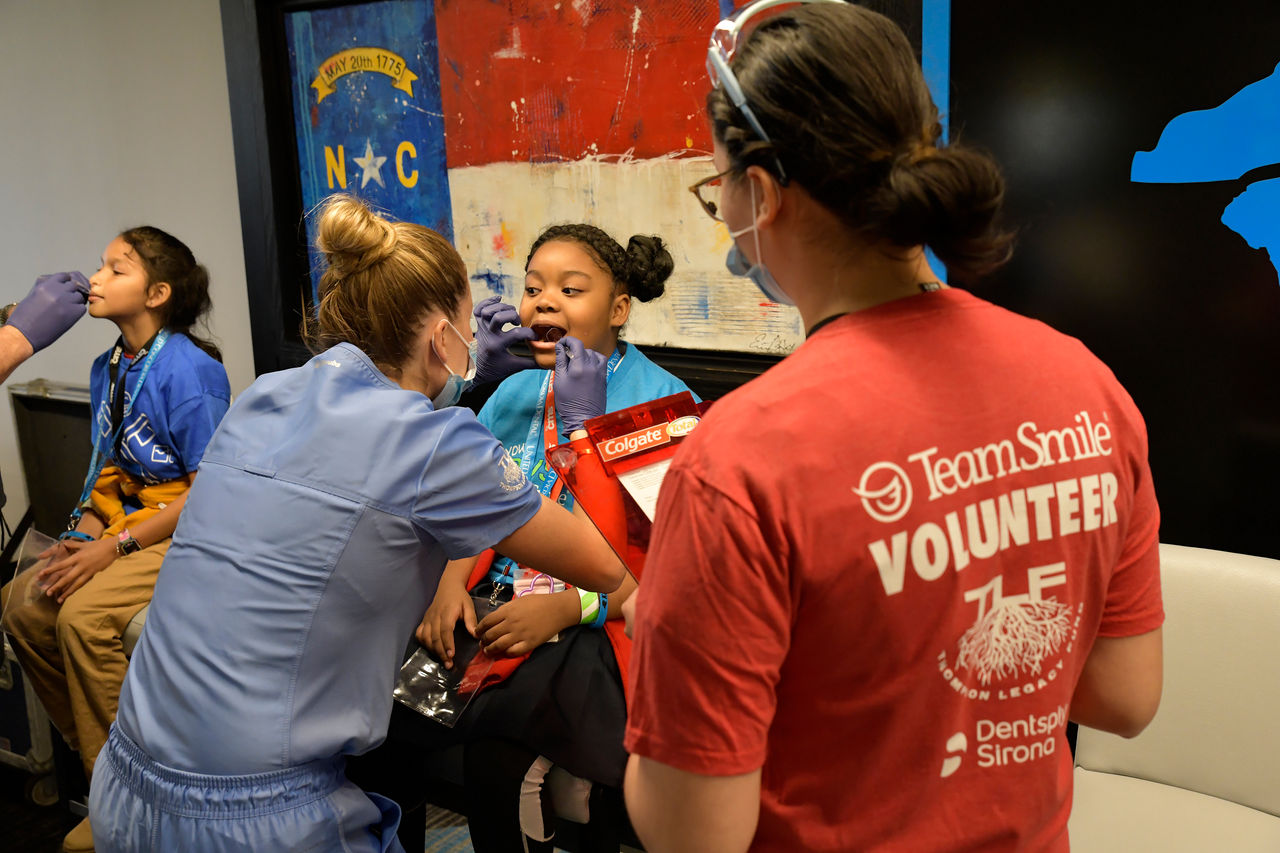 A girl is getting a dental check-up by a dentist